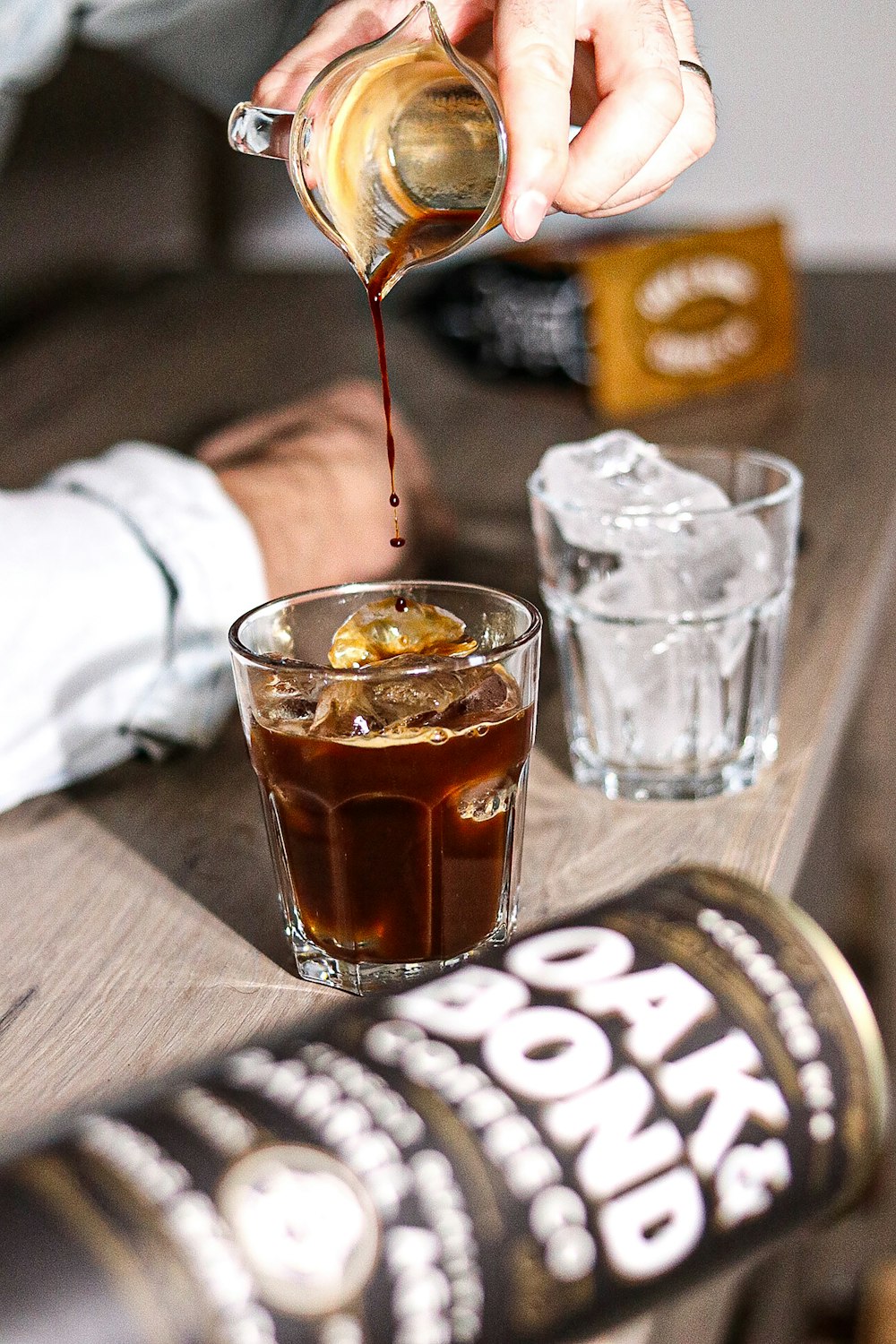 a person pouring a drink into a glass