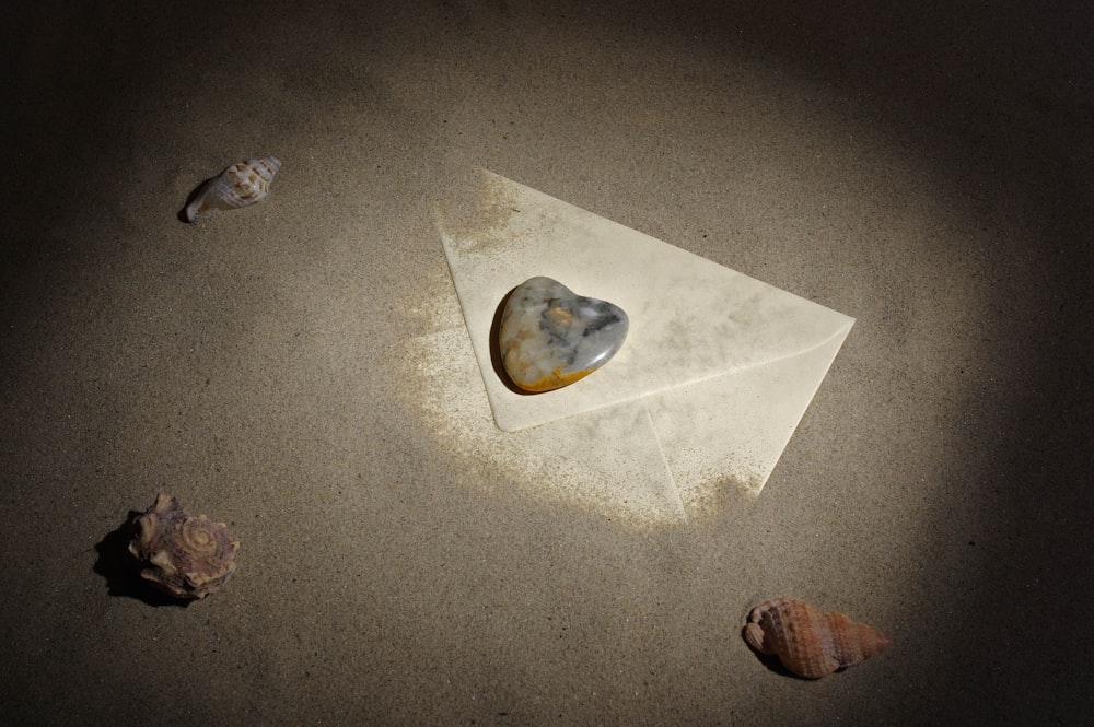 a heart shaped rock sitting on top of a piece of paper
