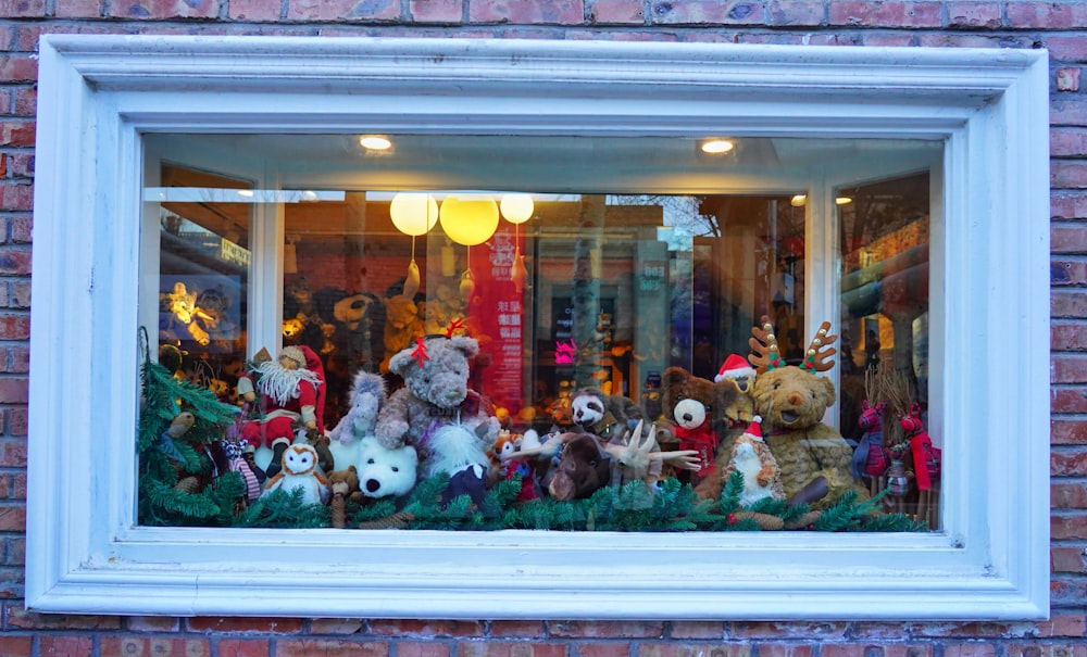 a bunch of stuffed animals sitting in a window