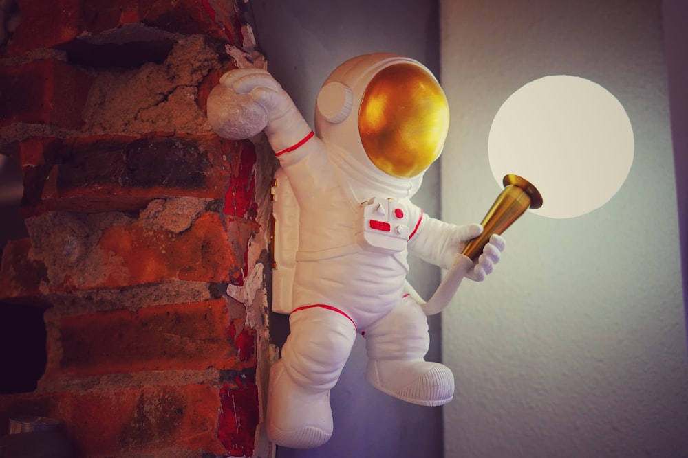 a toy astronaut holding a golden object in his hand