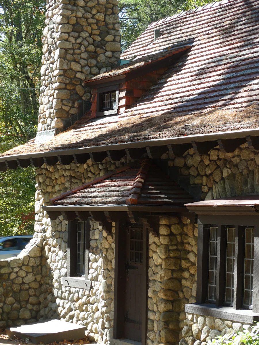 A river-rock stone home with a hand-laid stone chimney set among the trees