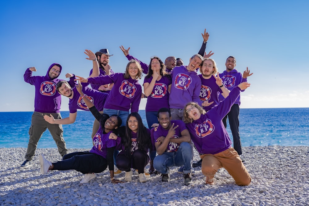 a group of people standing on top of a beach