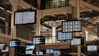 a bunch of television screens hanging from the ceiling