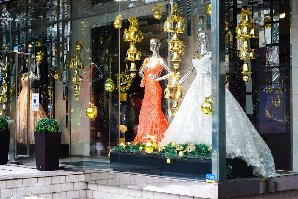 a window display with mannequins dressed in evening gowns
