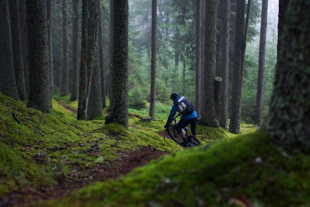 a man riding a mountain bike through a forest