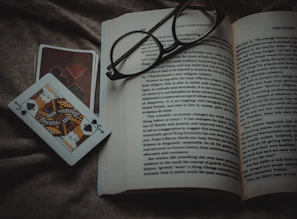 The King of Swords card laid open on a page of the Book of Tarot with a feather quill nearby