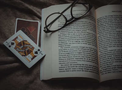 A close-up shot of a worn paperback copy of the casino book resting on a wooden table with a vintage poker chip beside it.