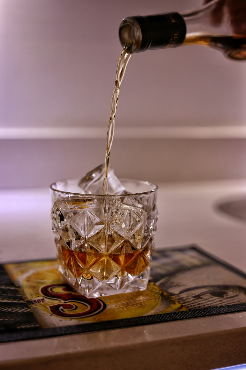 a glass of whiskey being poured into it