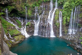 a group of people standing in front of a waterfall