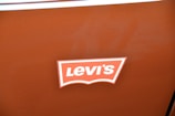 A brown surface features a logo with the word 'Levi's' in bold, white text on a red and white background.