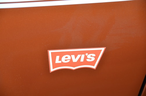 A brown surface features a logo with the word 'Levi's' in bold, white text on a red and white background.