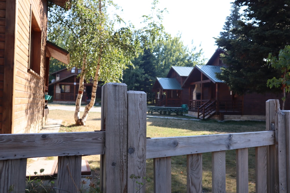 a wooden fence in front of a wooden house