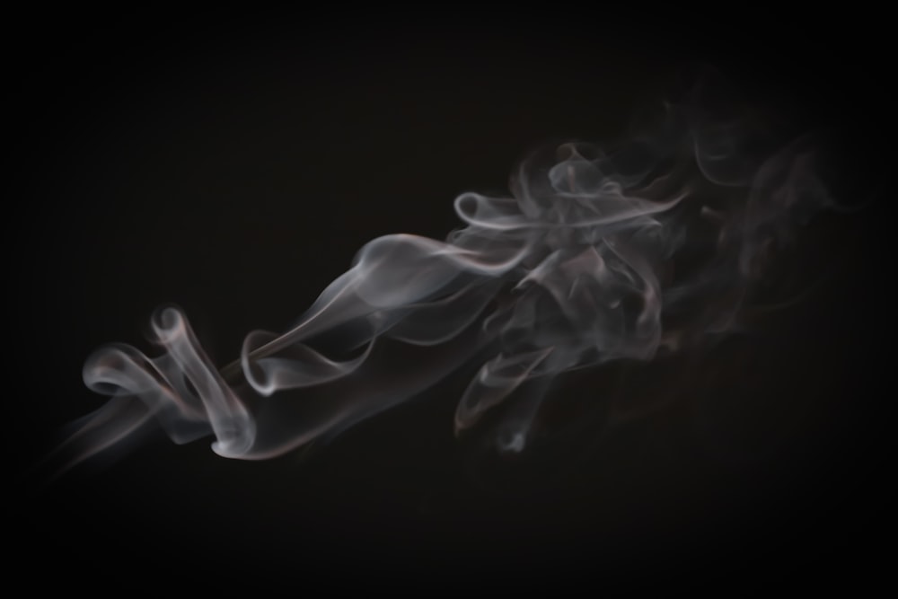 smoke is shown in the dark on a black background