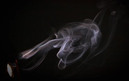 the smoke is blowing in the dark on the clock