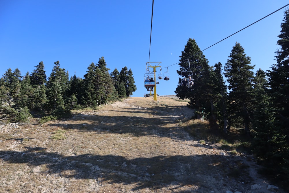a ski lift going up a hill with trees