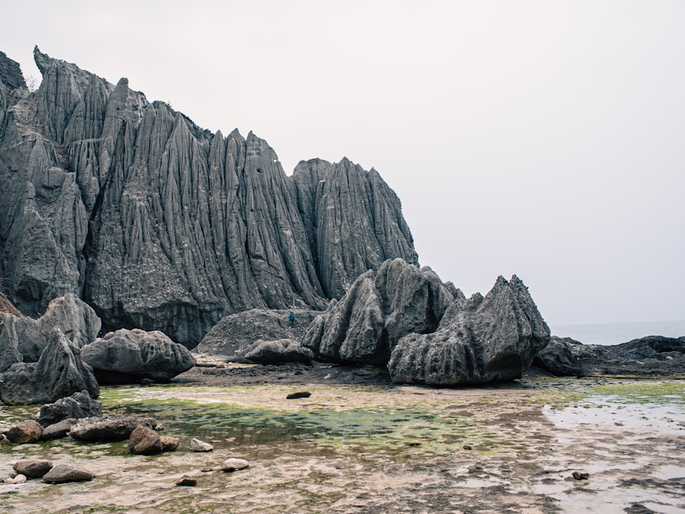 a large rock formation in the middle of a beach