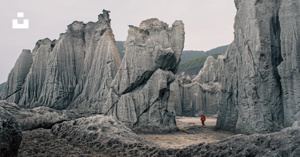 A person standing in between two large rocks photo – Free Hotokegaura ...