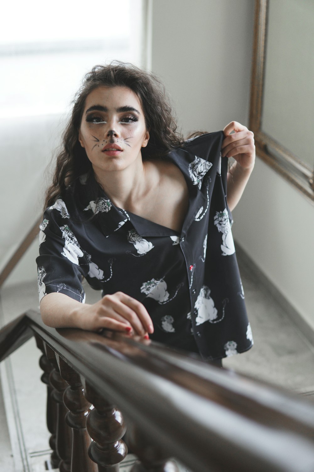 a woman in a black and white shirt leaning on a railing