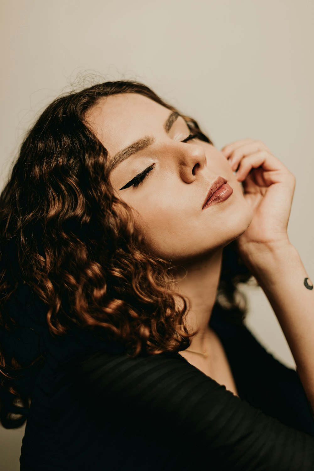 a woman with curly hair is posing for a picture