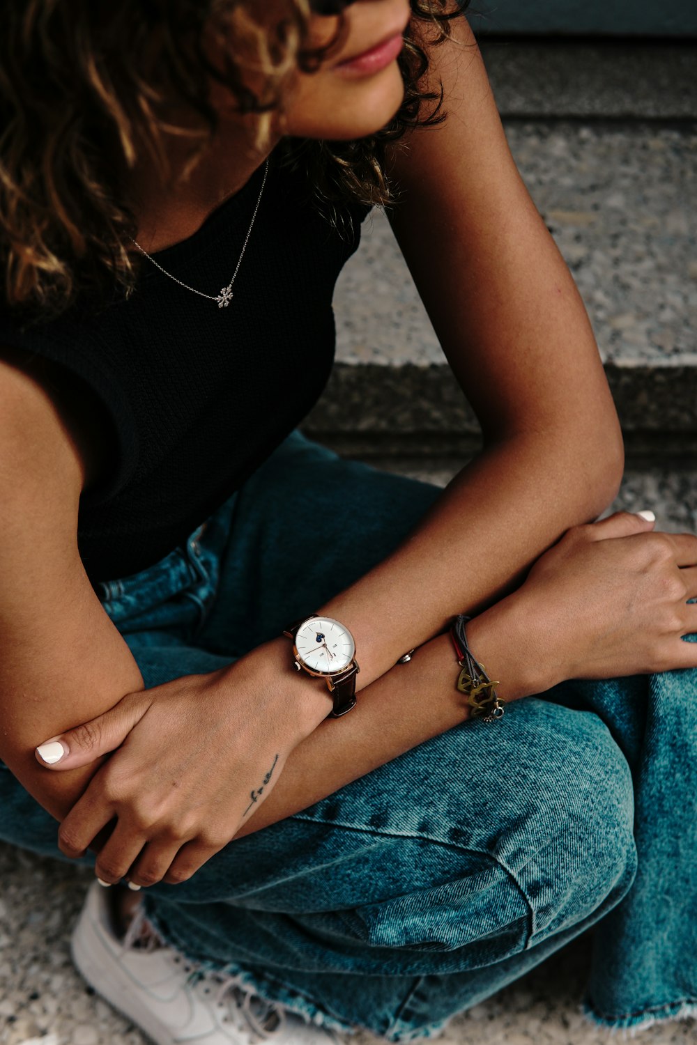 a woman sitting on the ground wearing a watch