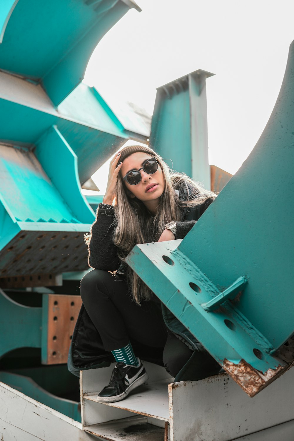 a woman sitting on top of a metal structure