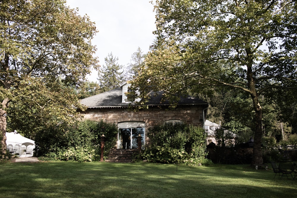 an old brick house surrounded by trees and grass