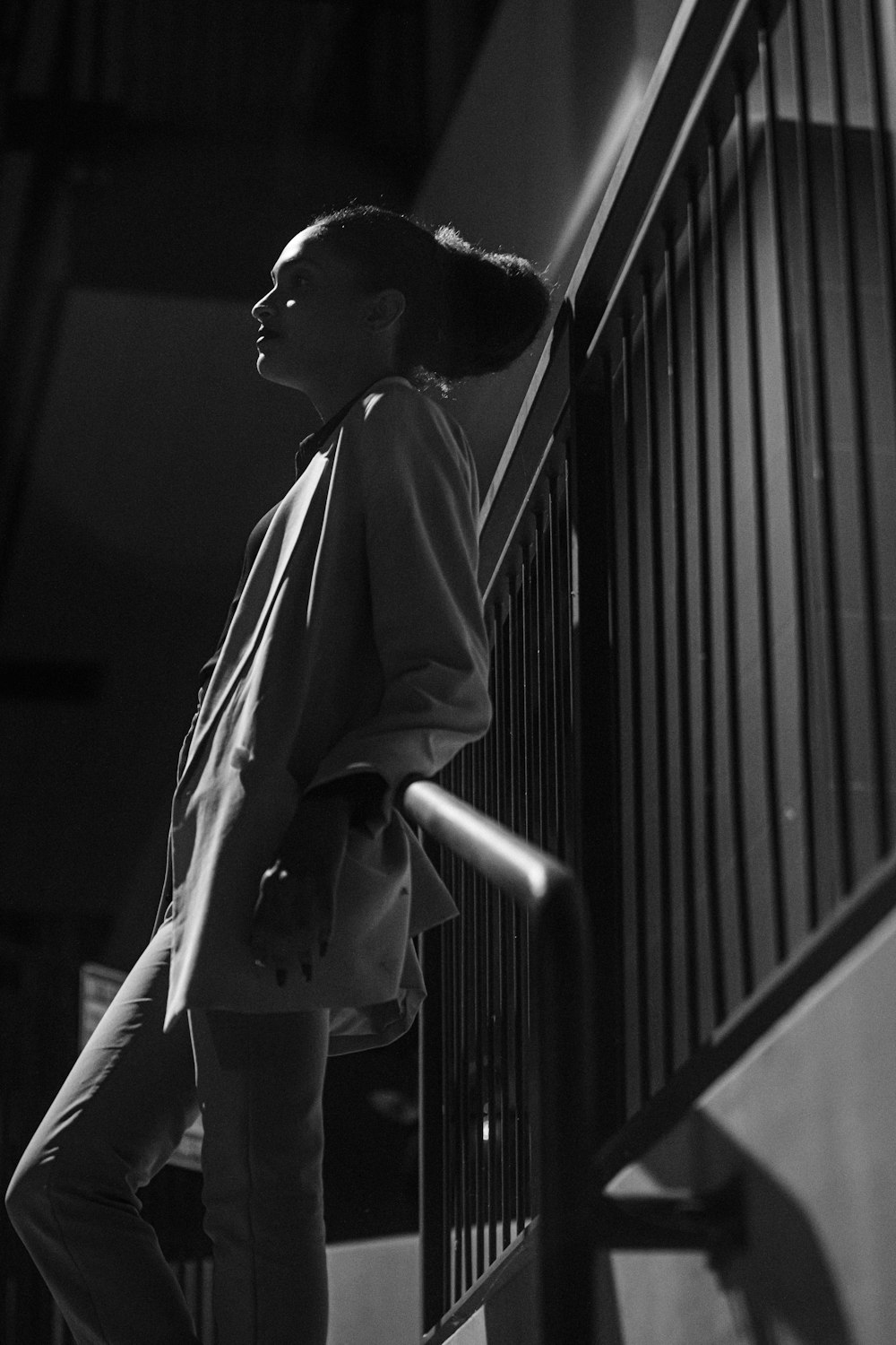 a woman standing on a stair case next to a railing