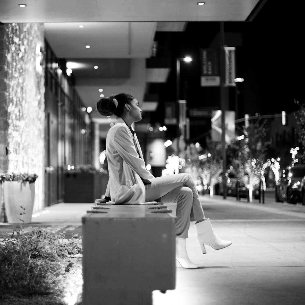 a woman sitting on top of a cement block