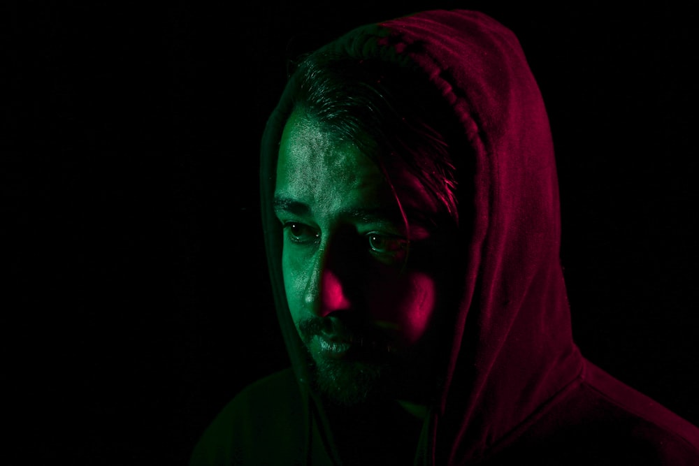 a man with a hoodie on in the dark