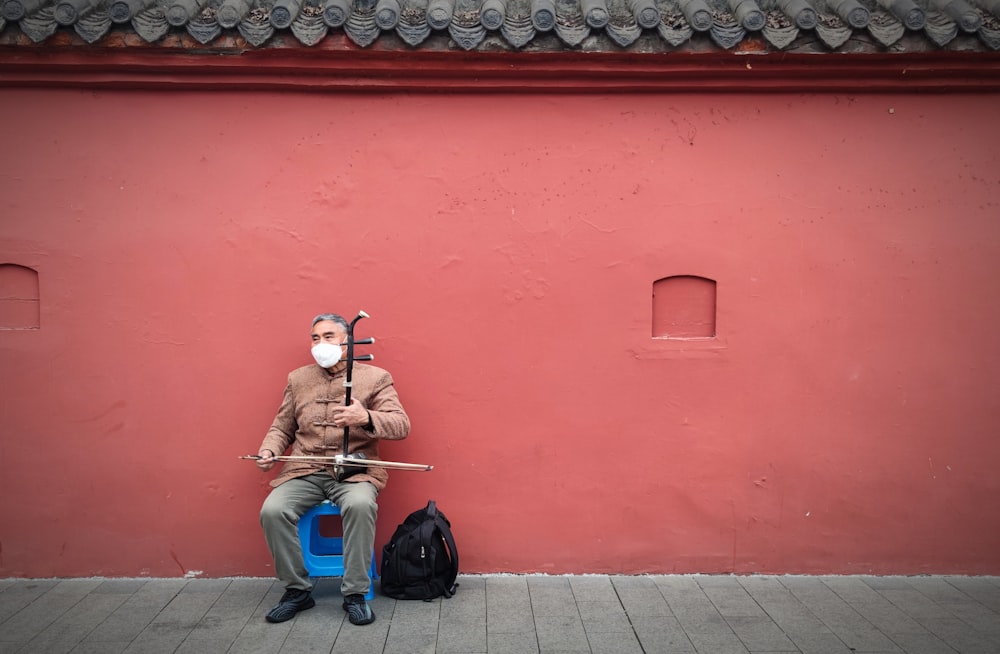 a man sitting on a bench with a mask on