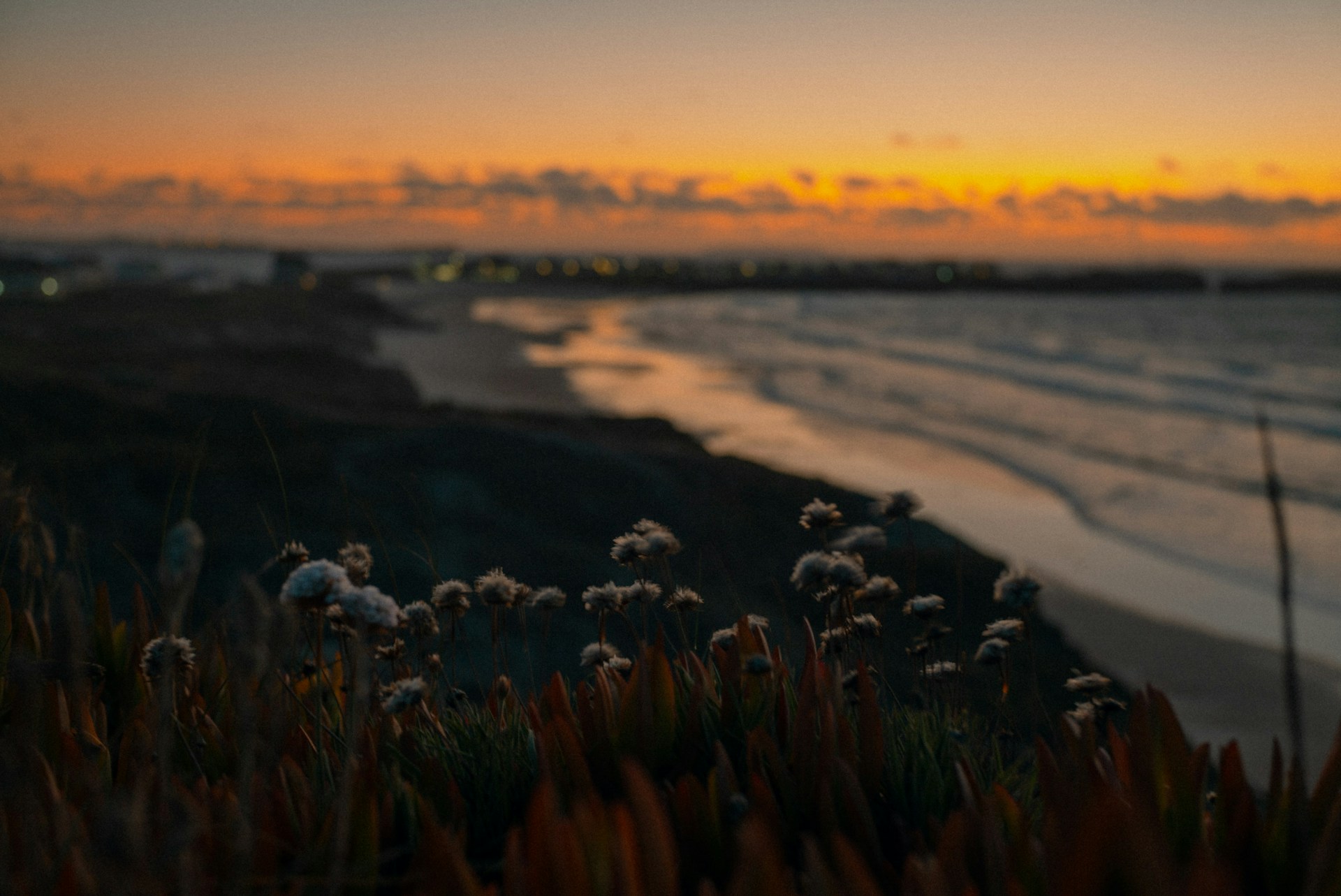 the sun is setting over the ocean and a beach
