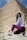 a woman sitting on the ground in front of a pyramid