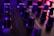 A close-up of a mixing console with colorful sound wave visuals on a screen.