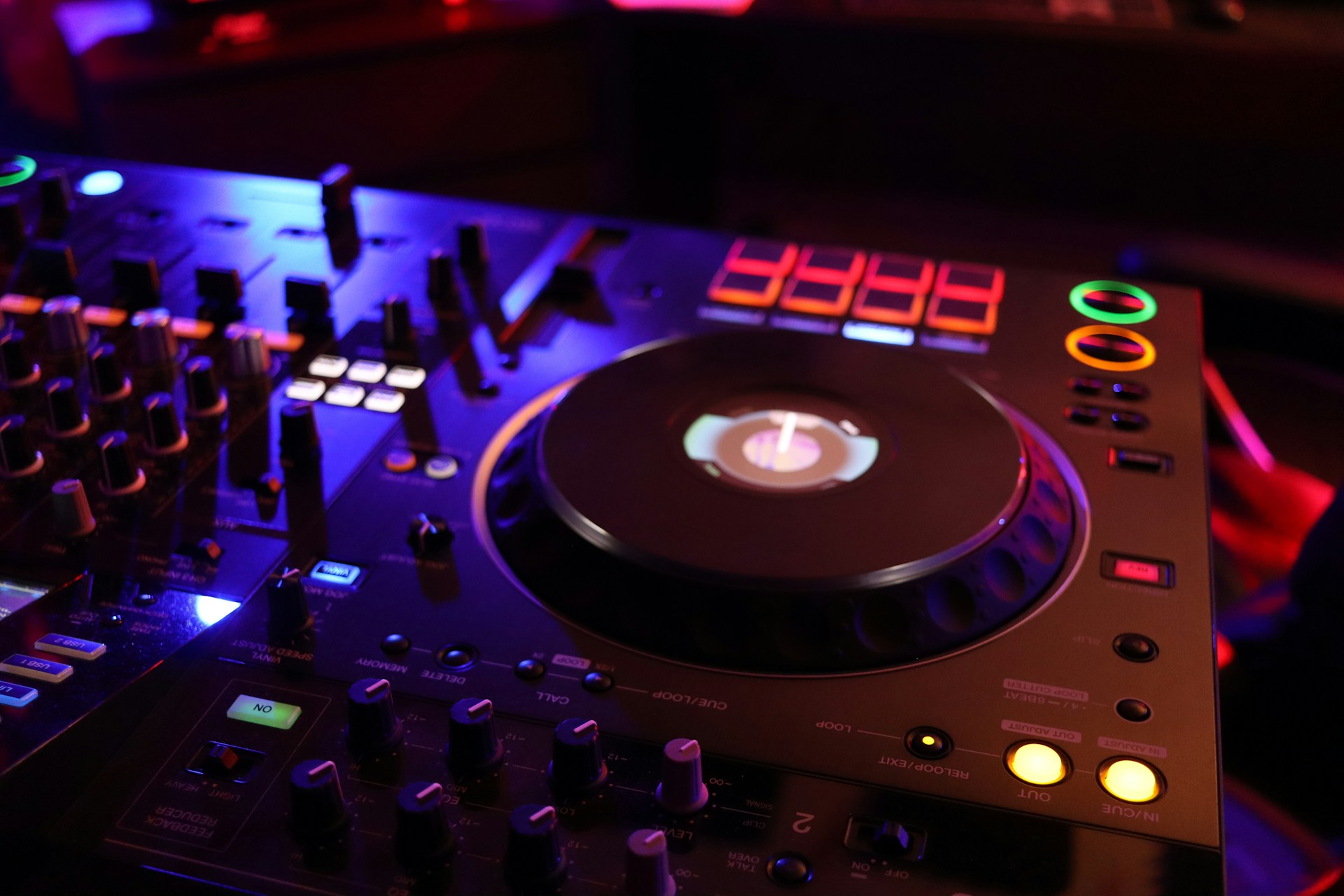 a dj's turntable and controller in a dark room