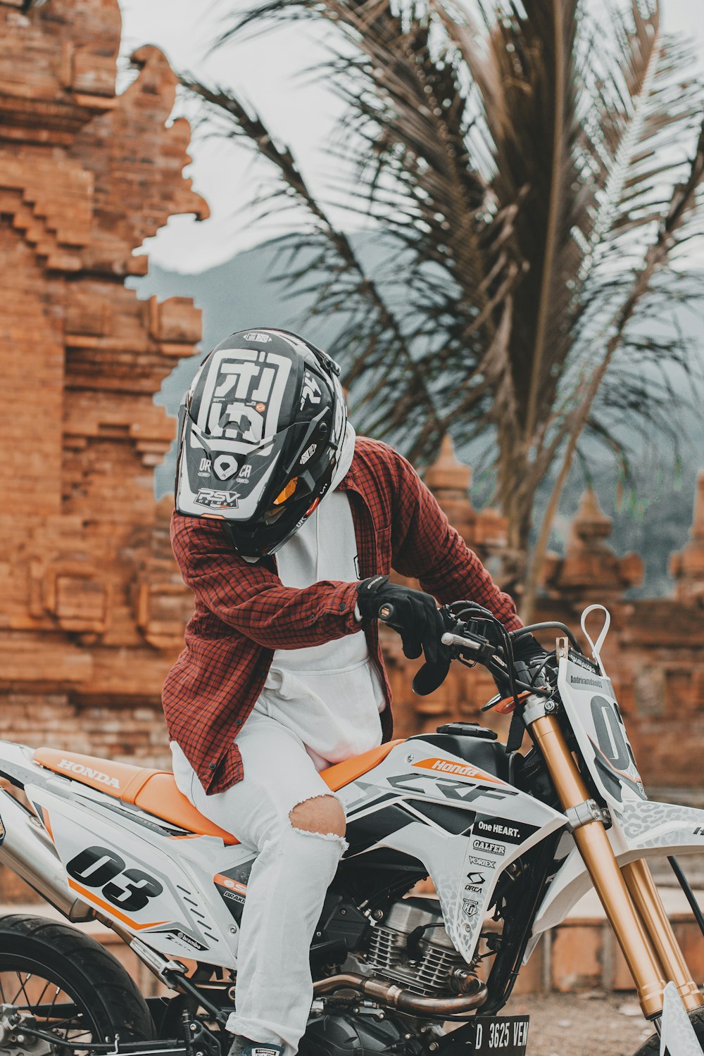 a man sitting on a motorcycle wearing a helmet