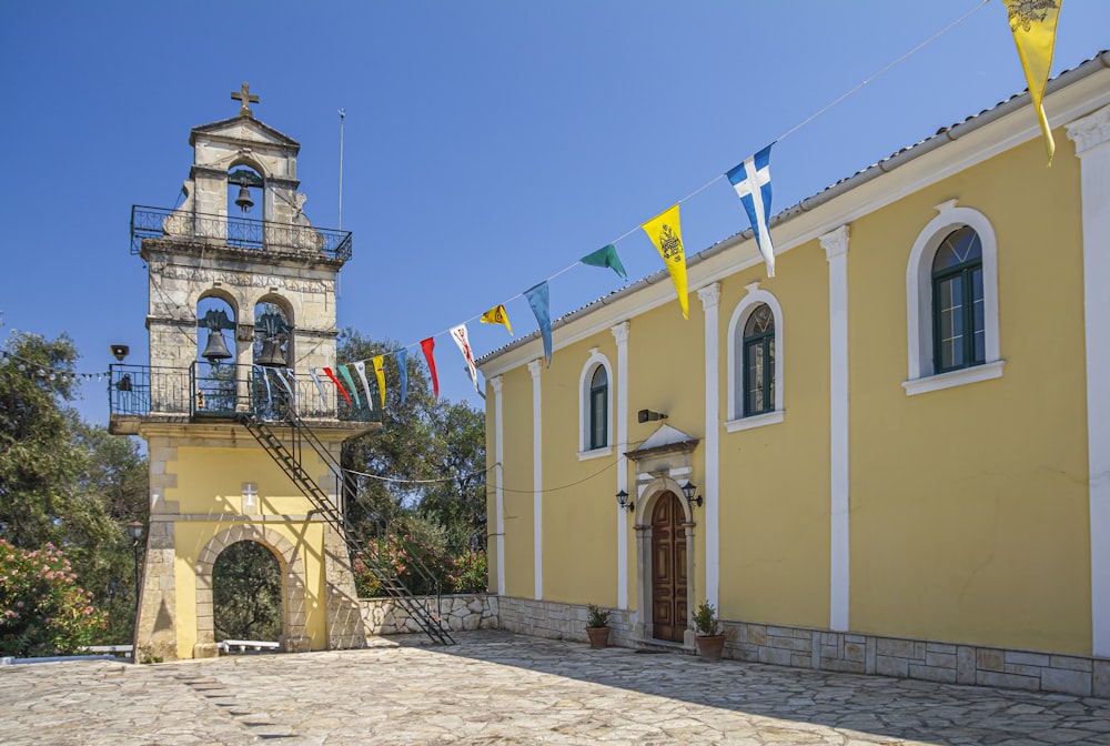 a yellow building with a clock tower in the background