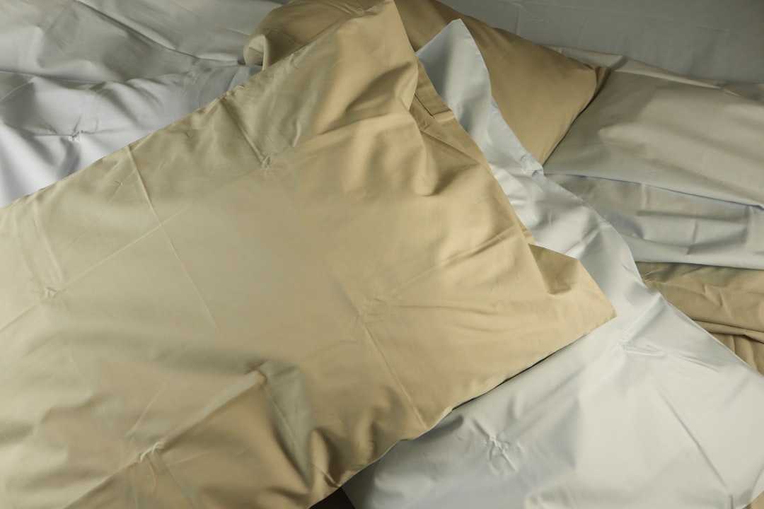 a pile of pillows sitting on top of a bed,