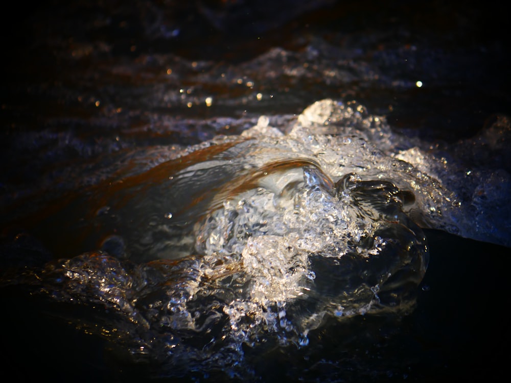 a close up of water with a rock in the middle of it