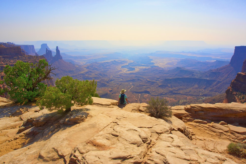 a person standing on top of a mountain overlooking a valley