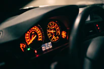 Close-up of a custom car dashboard illuminated by vibrant orange lights in a dark setting.