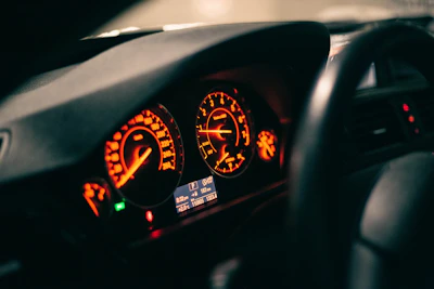 Close-up of a custom car dashboard illuminated by vibrant orange lights in a dark setting.