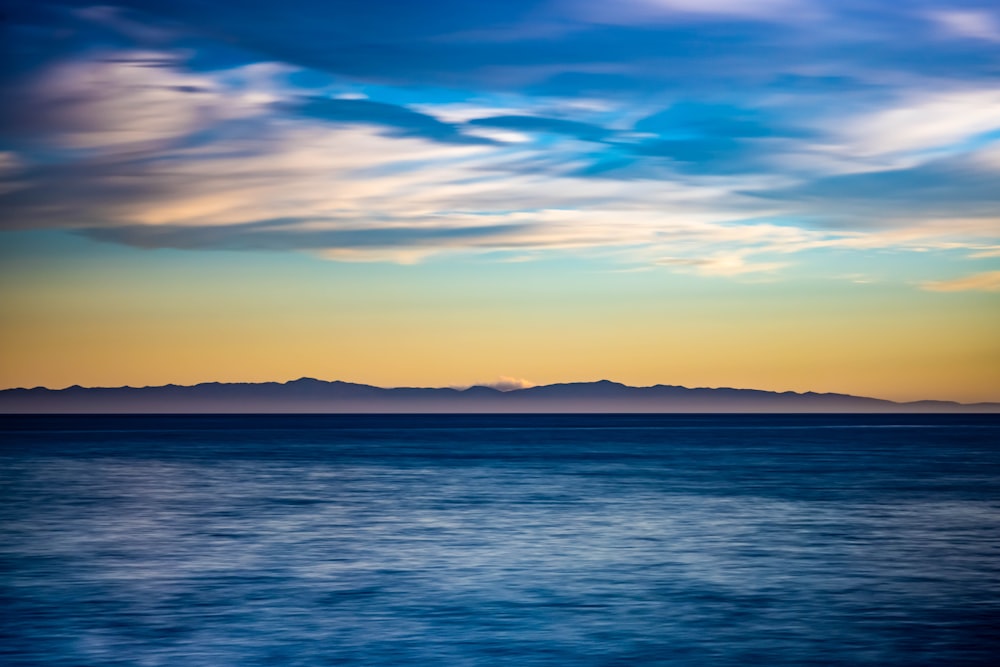 a large body of water under a cloudy sky