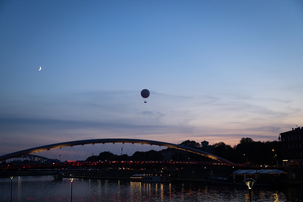 a hot air balloon flying over a river