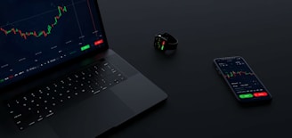 a laptop computer sitting next to a cell phone