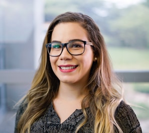 a woman with glasses smiling for the camera