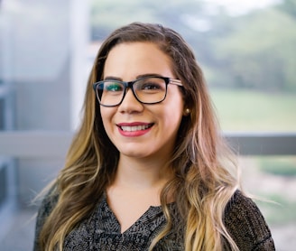 a woman with glasses smiling for the camera