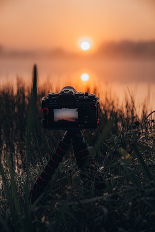 A camera on a tripod overlooking a serene lake during golden hour, perfect for beginner shots.
