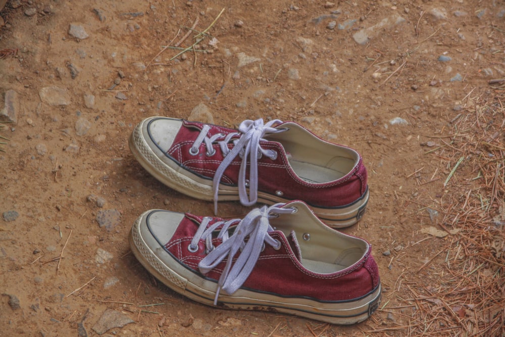 a pair of red shoes with white laces on them