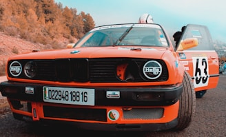 an orange car parked on the side of the road