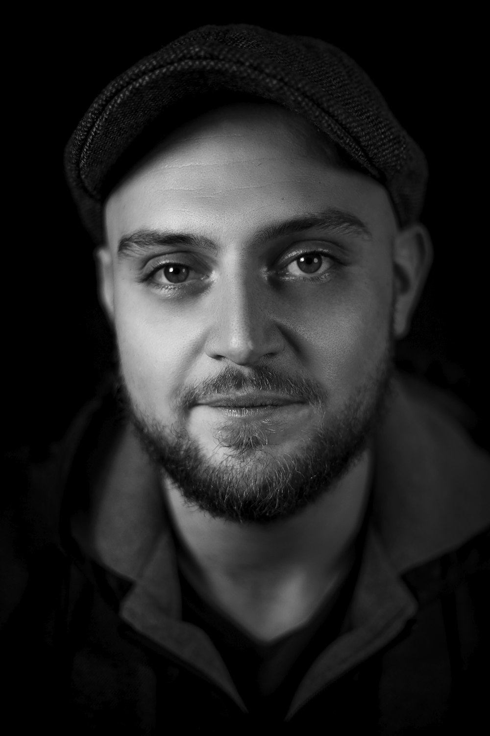 a black and white photo of a man wearing a hat